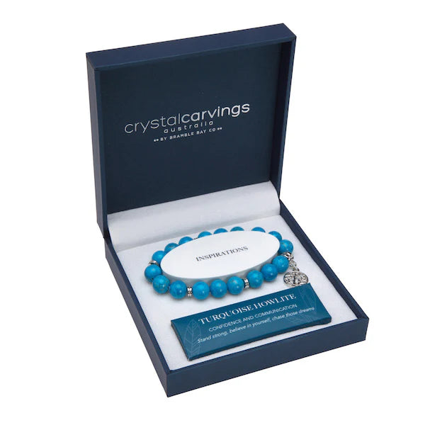 Turquoise beaded bracelet with a heart charm in a 'Crystal Carvings' box on a white background